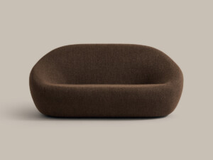 Brown upholstered lounge sofa with rounded shape on neutral background
