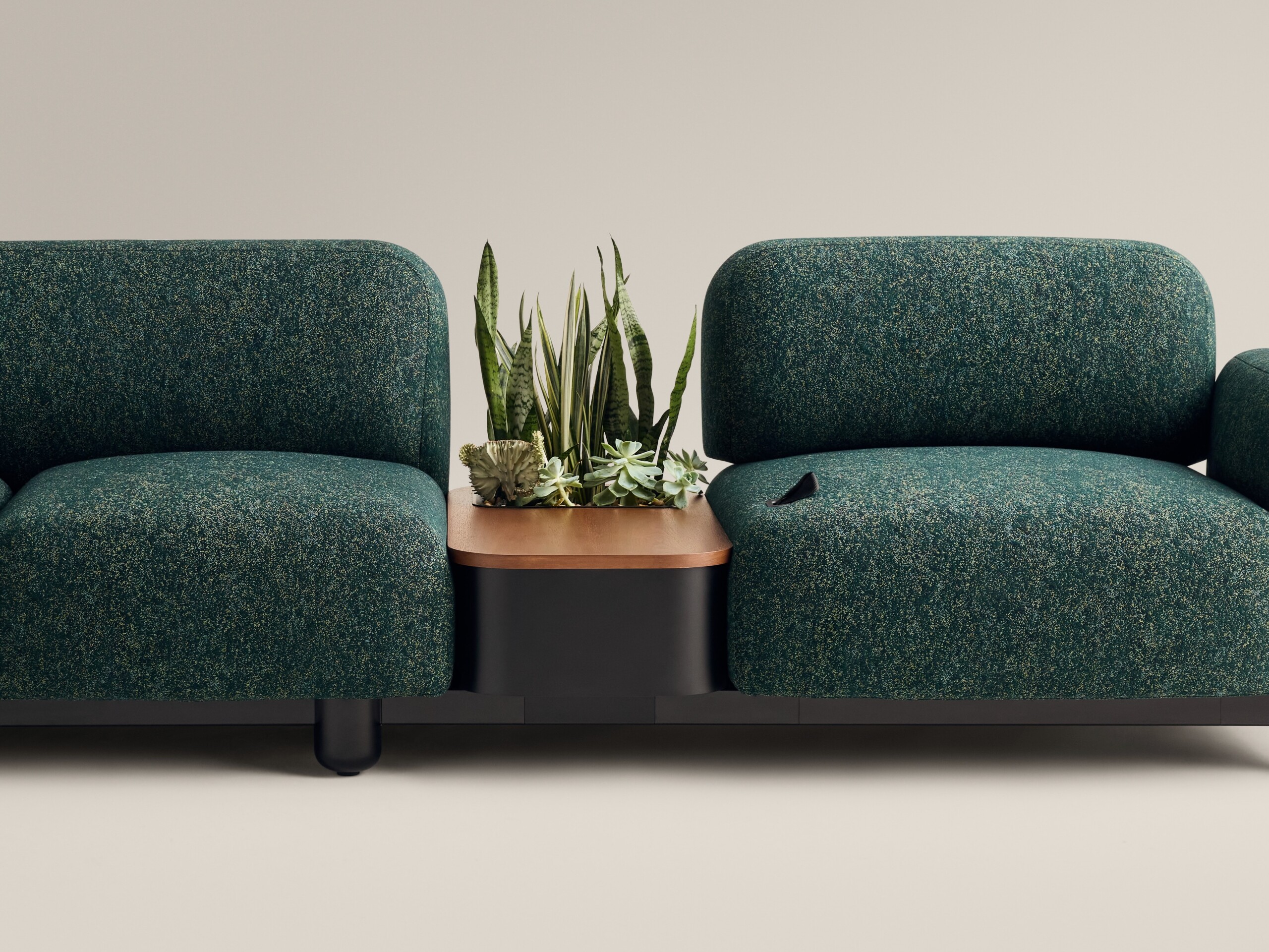 Two Ensemble couches in emerald color next to one another.