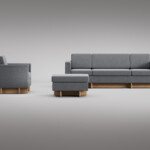 Gray sofa, armchair, and ottoman with wooden bases displayed against a neutral background.