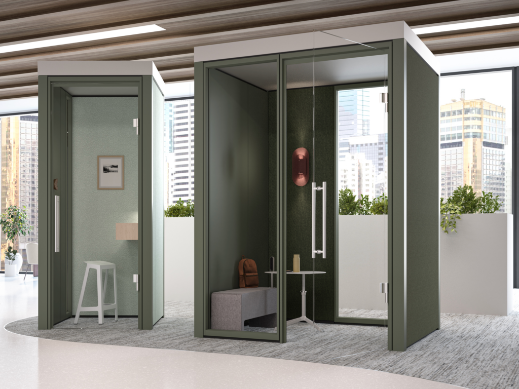 Office workspace with two enclosed acoustic booths featuring glass doors, and city views through large windows.