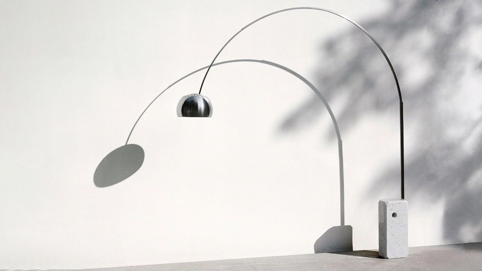 Floor lamp with a metallic dome shade anchored to a rectangular marble base on a white background