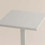 Close up view of white table on neutral background.