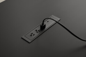 Close-up of black table with integrated power outlet