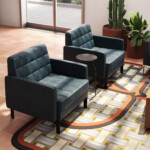Modern lounge area with upholstered armchairs, side table, patterned rug, and wood coffee table