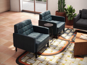 Modern lounge area with upholstered armchairs, side table, patterned rug, and wood coffee table