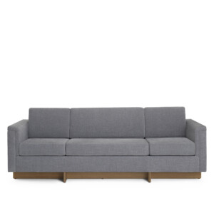Modern gray upholstered sofa with wood base on neutral background