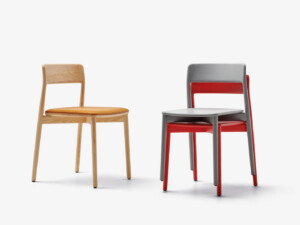 Two stacked chairs on a white background, one in natural wood and one in gray and red