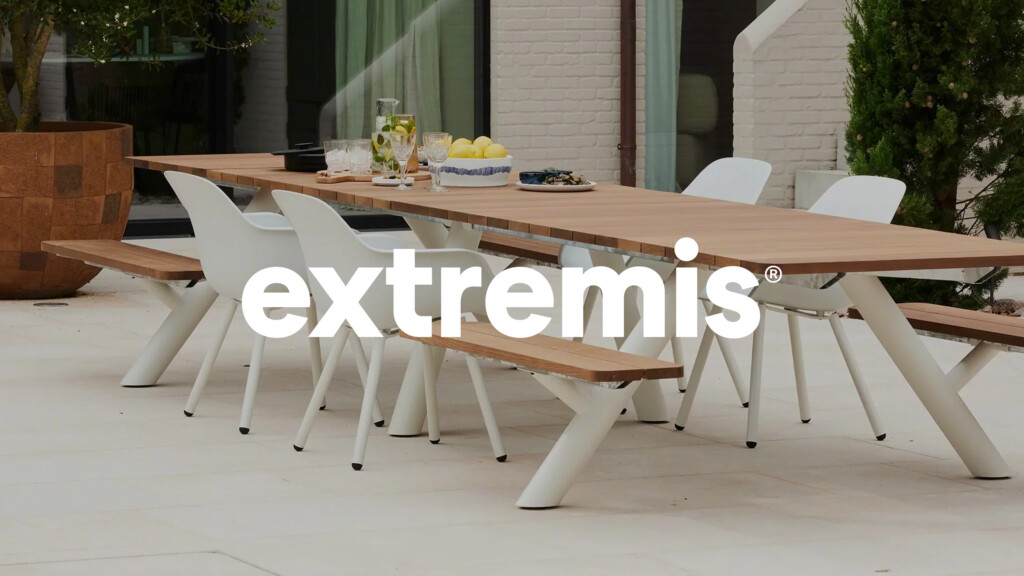 Outdoor dining setup with long wooden table, white chairs, and benches for partner Extremis