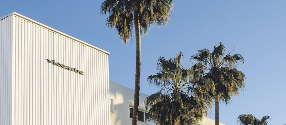 Viccarbe Building framed by palm trees and clear blue sky