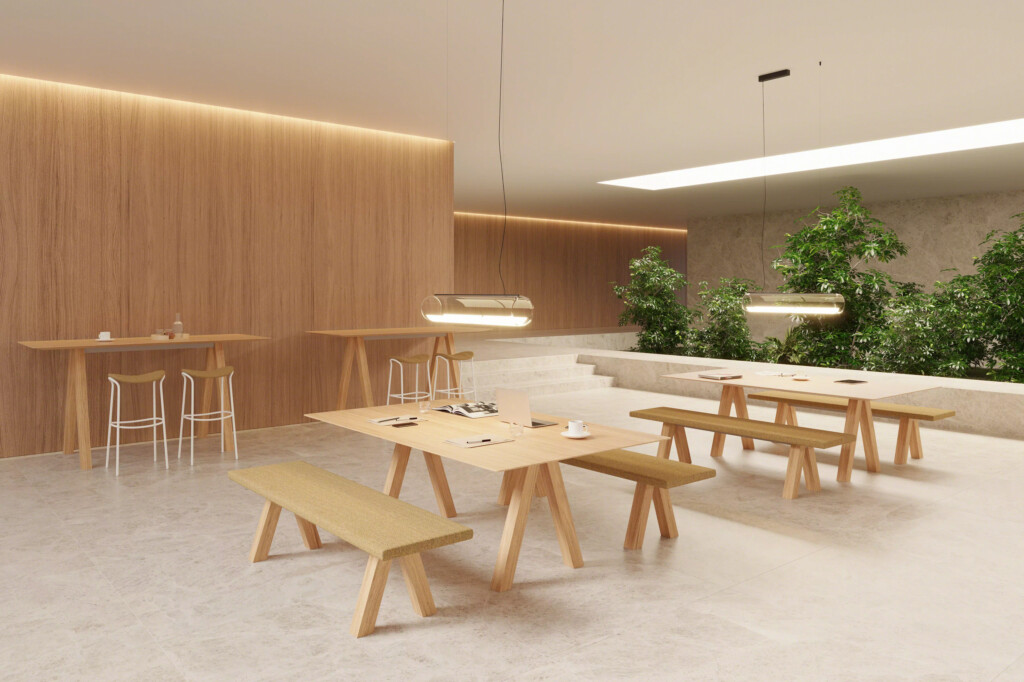 Work cafe area with wooden tables and benches in a modern, bright interior