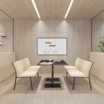 Minimalist meeting room with a table and four cream chairs facing a screen in the middle of the room.