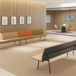 Two benches facing each other inside a waiting room with wooden walls and paintings hanging.
