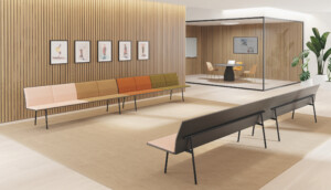 Two benches facing each other inside a waiting room with wooden walls and paintings hanging.