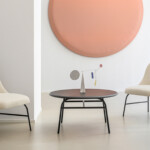 Indoor space with two cream lounge chair and a small black table in the center