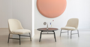 Indoor space with two cream lounge chair and a small black table in the center