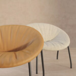 One yellow lounge chair next to a cream lounge chair displayed with a beige background.