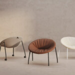 Three multicolor lounge chairs displayed in a beige room.