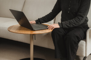 woman seated in a sofa while working on a laptop in front of her